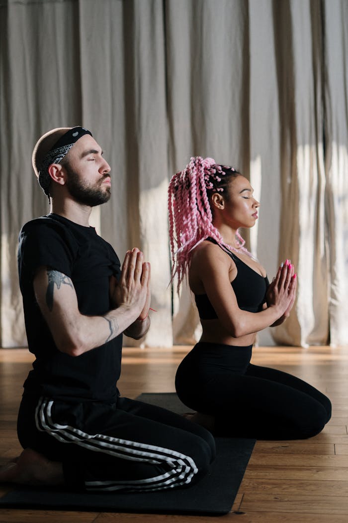 Two people practicing yoga indoors, focusing on mindfulness and relaxation. Perfect for wellness themes.